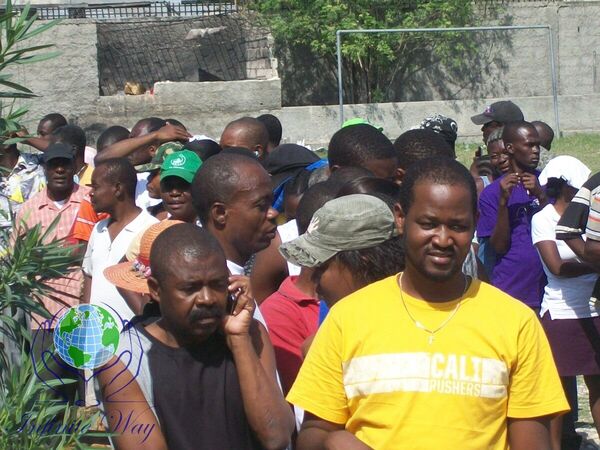 People unloading bags and boxes of donated goods from a truck in Haiti